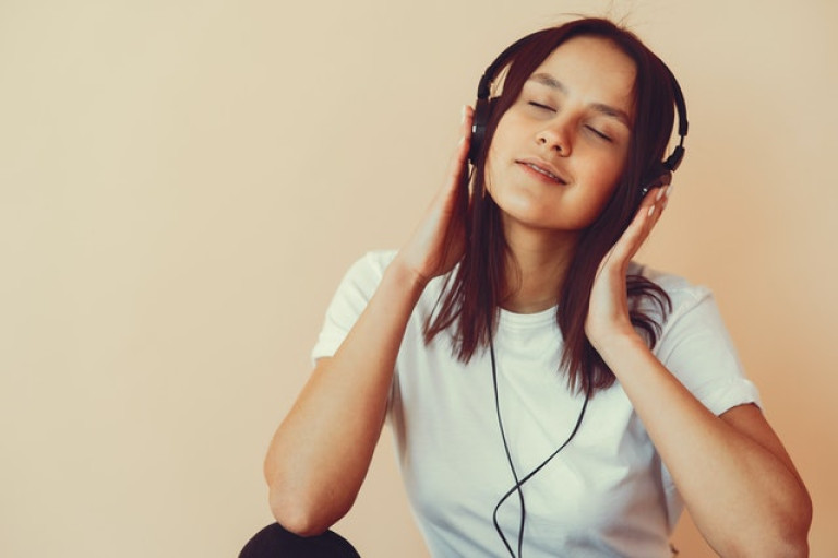 dreamy-young-woman-listening-to-music-in-headphones-4127625